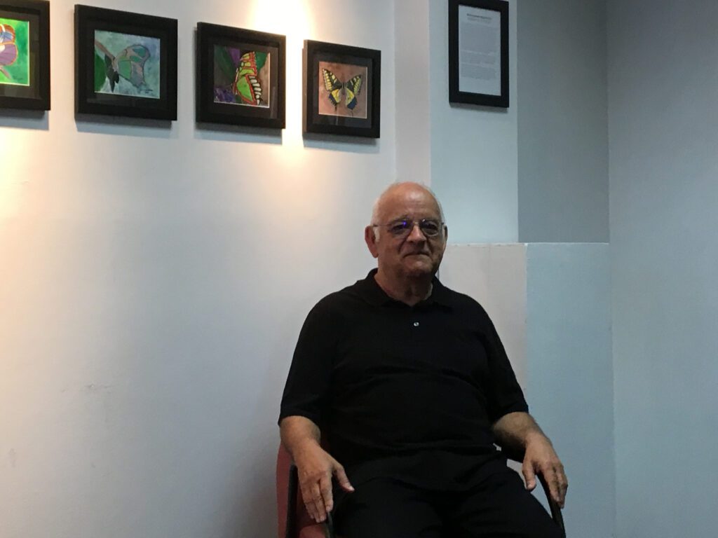 man sitting in front of a painting